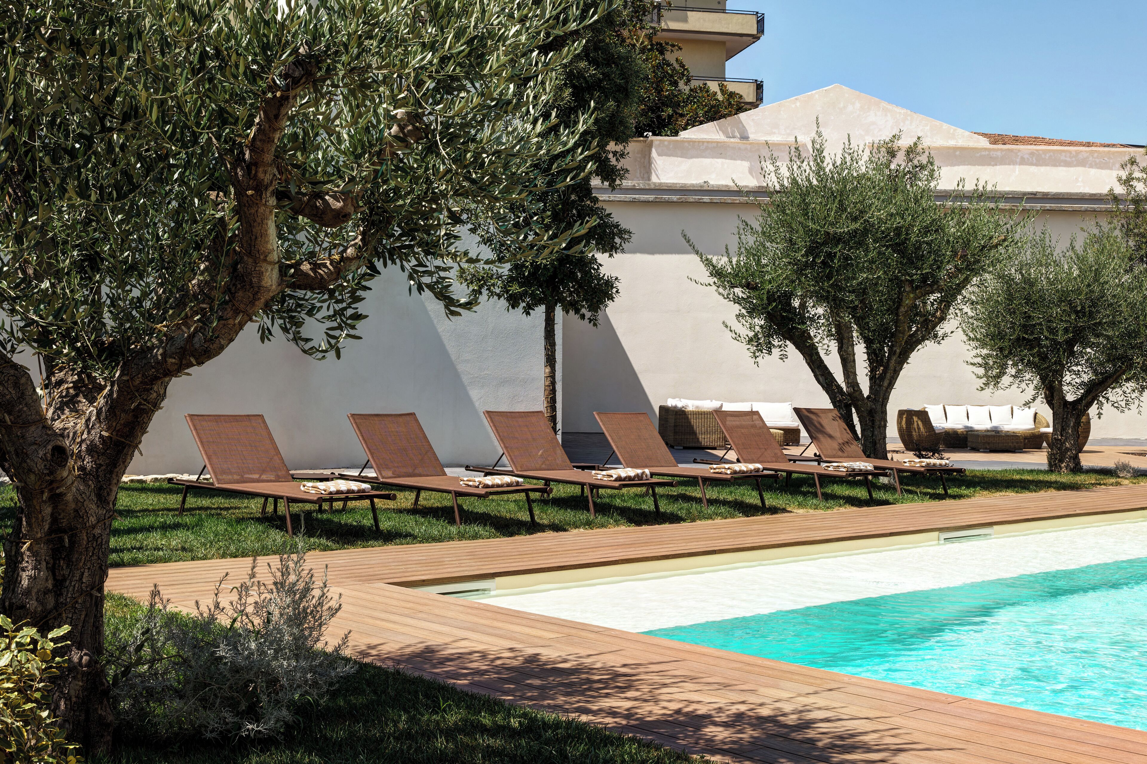 A poolside area with lounge chairs and a swimming pool.