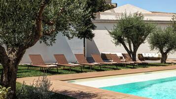 A poolside area with lounge chairs and a swimming pool.