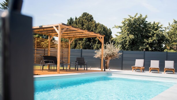 A swimming pool with lounge chairs and a wooden pergola. - Résidence des Sables (Mably)