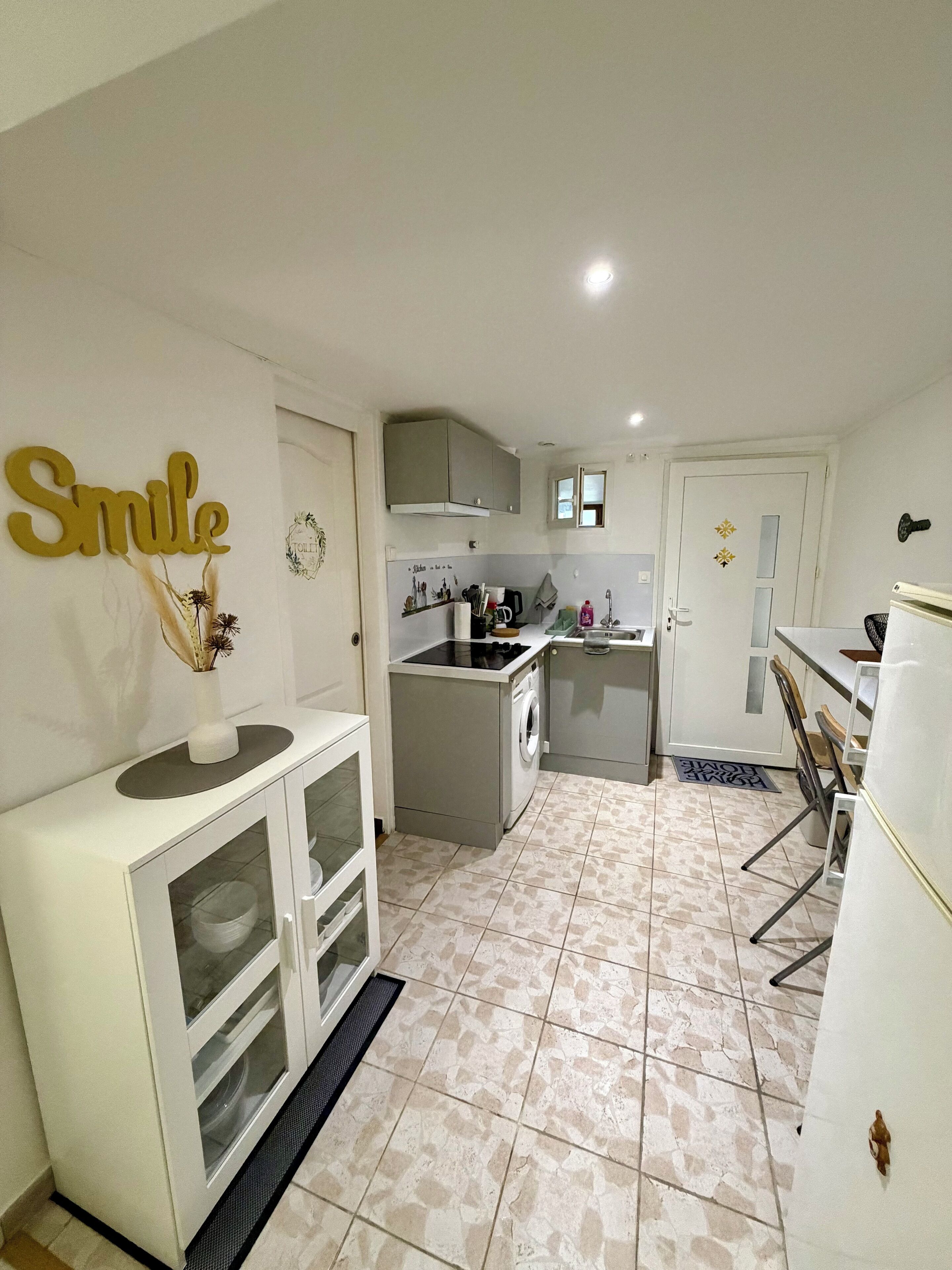 A compact kitchen with white cabinets, a built-in oven, and a sink.