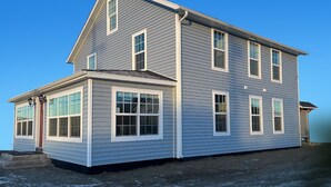 A two-story house with a gabled roof, multiple windows, and a front porch. - Palmer Suite 101, Hyland Hotel (Palmer)