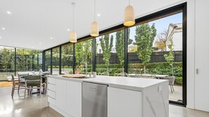 A modern kitchen with a large island, stainless steel appliances, and pendant lighting.