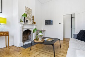 A living room with a fireplace, a television, and a sofa. - Donatella, Where Heritage Meets Haute Living (Bendigo)