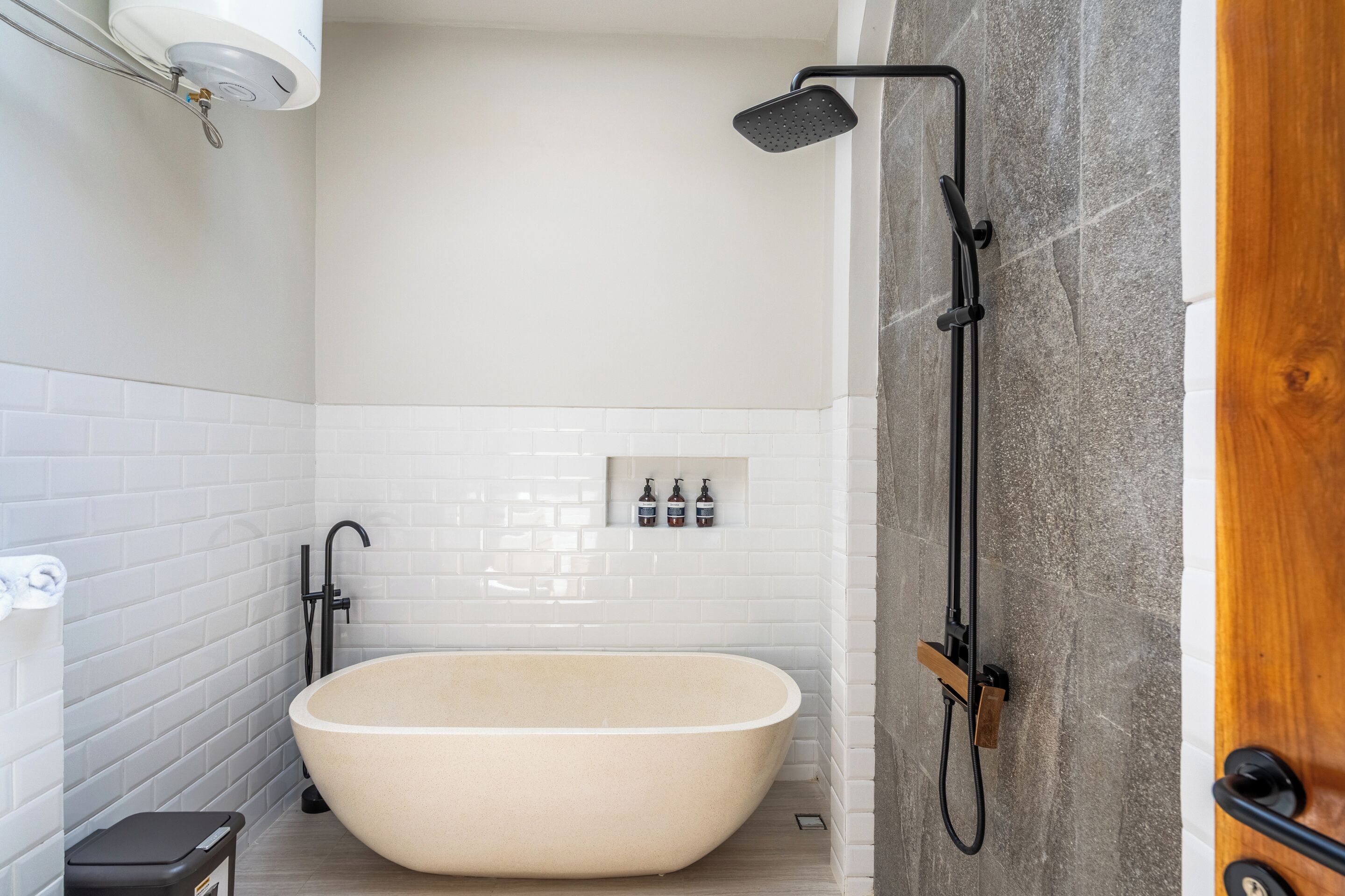 A modern bathroom with a freestanding bathtub, a showerhead, and a towel rack.