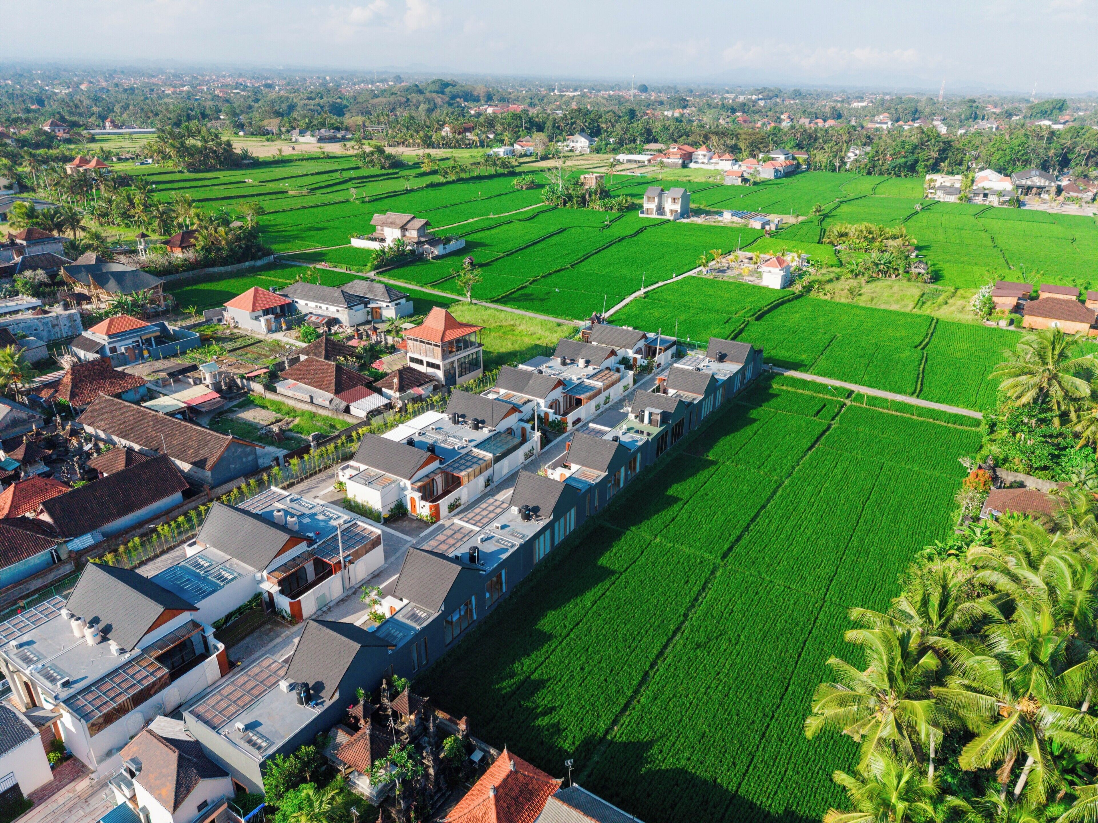A residential area with houses and green fields.