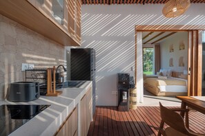 A modern kitchen with a built-in stove, a coffee machine, and a water dispenser. - Amartya Villa by Betterplace (Ubud)