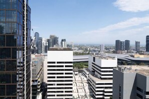 A cityscape with modern high-rise buildings, one with a white facade and multiple floors. - 1B1B Condo with Bay &River Views (Docklands)