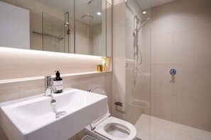 A bathroom with a white sink, a toilet, and a glass-enclosed shower. - 1B1B Condo with Bay &River Views (Docklands)