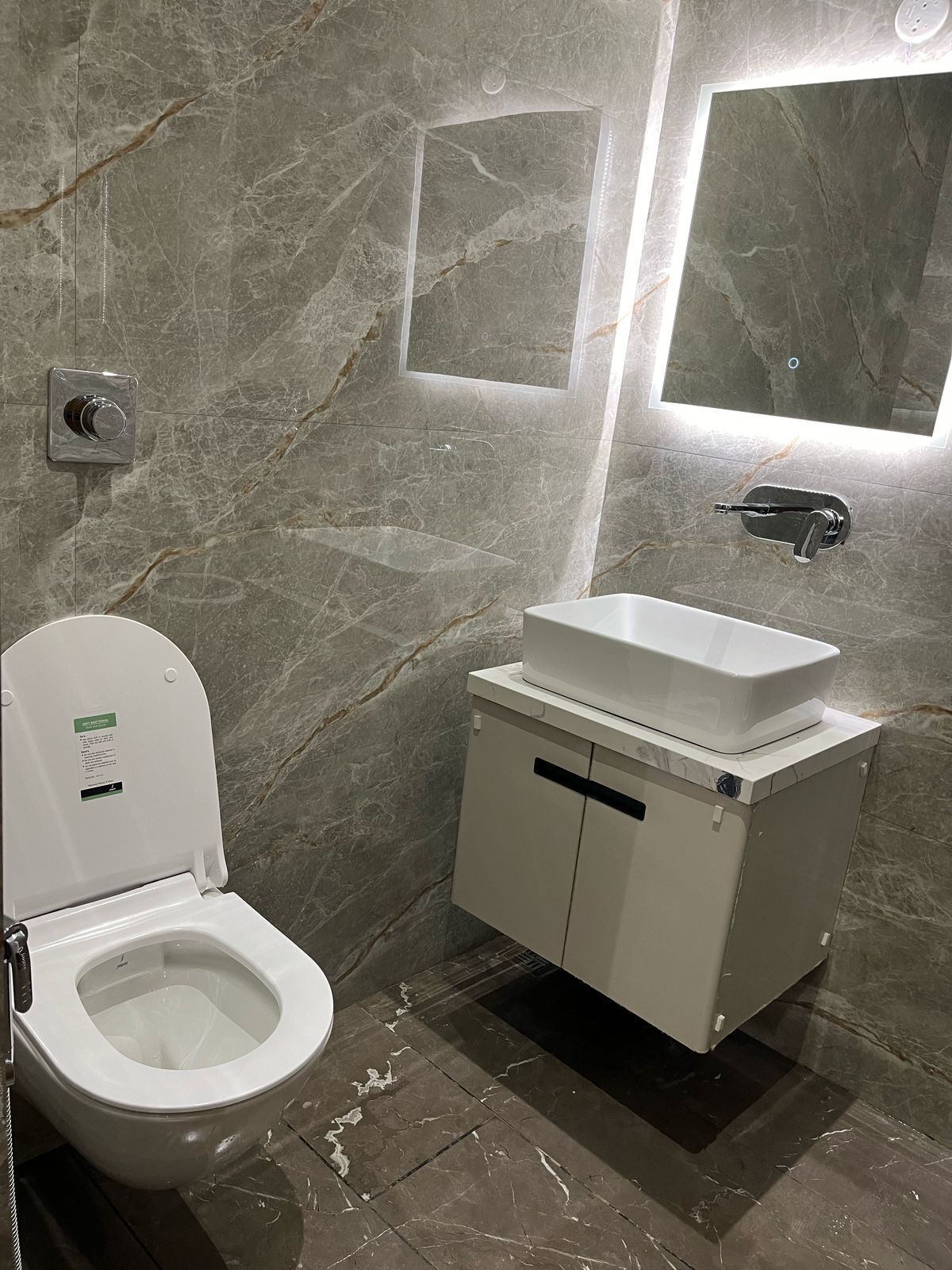 A bathroom with a toilet, a sink, and a mirror.