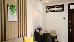 Una sala de estar moderna con un sofá, una mesa de comedor con sillas, un equipo de aire acondicionado instalado en la pared y una obra de arte enmarcada.