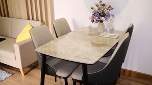 Una mesa de comedor con sillas, un jarrón con flores y una vela sobre la mesa.