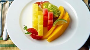 Ein weißer Teller mit Obstscheiben und einem Limettenschnitz.