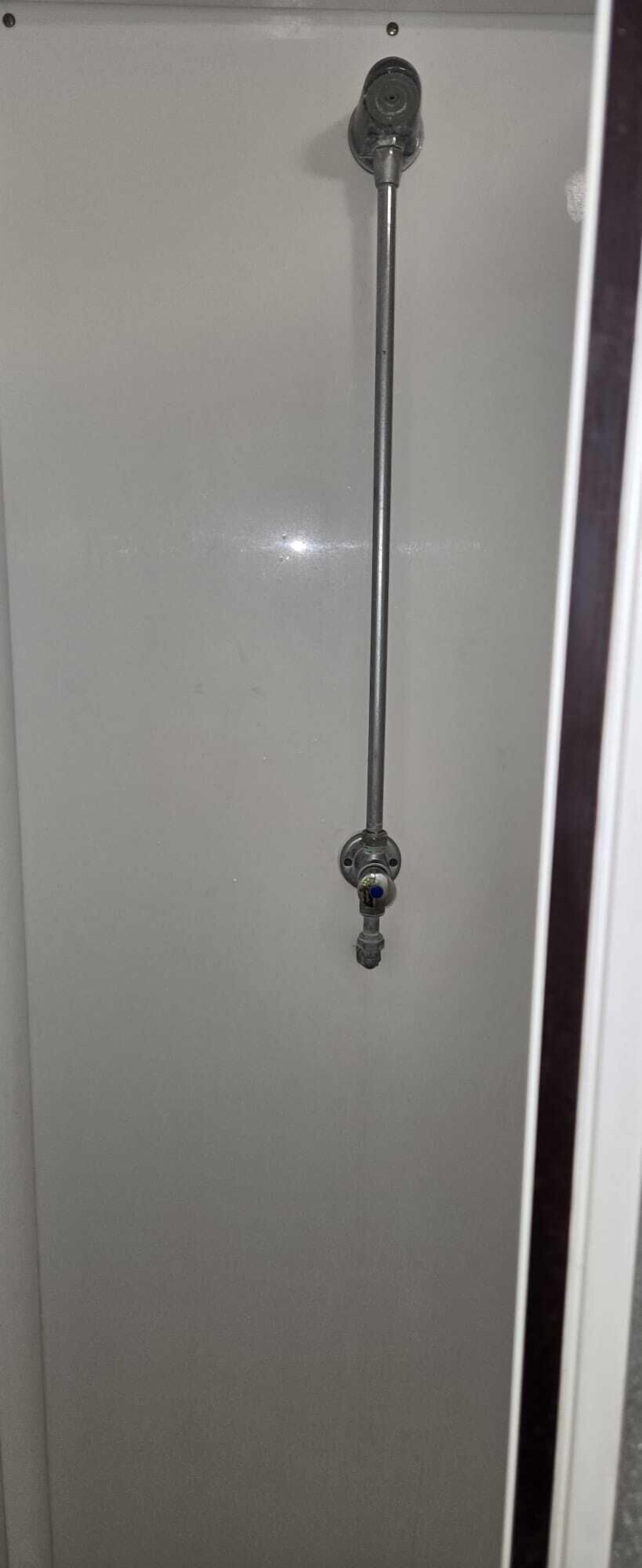 A metallic handle on a white door, likely for a bathroom or closet.