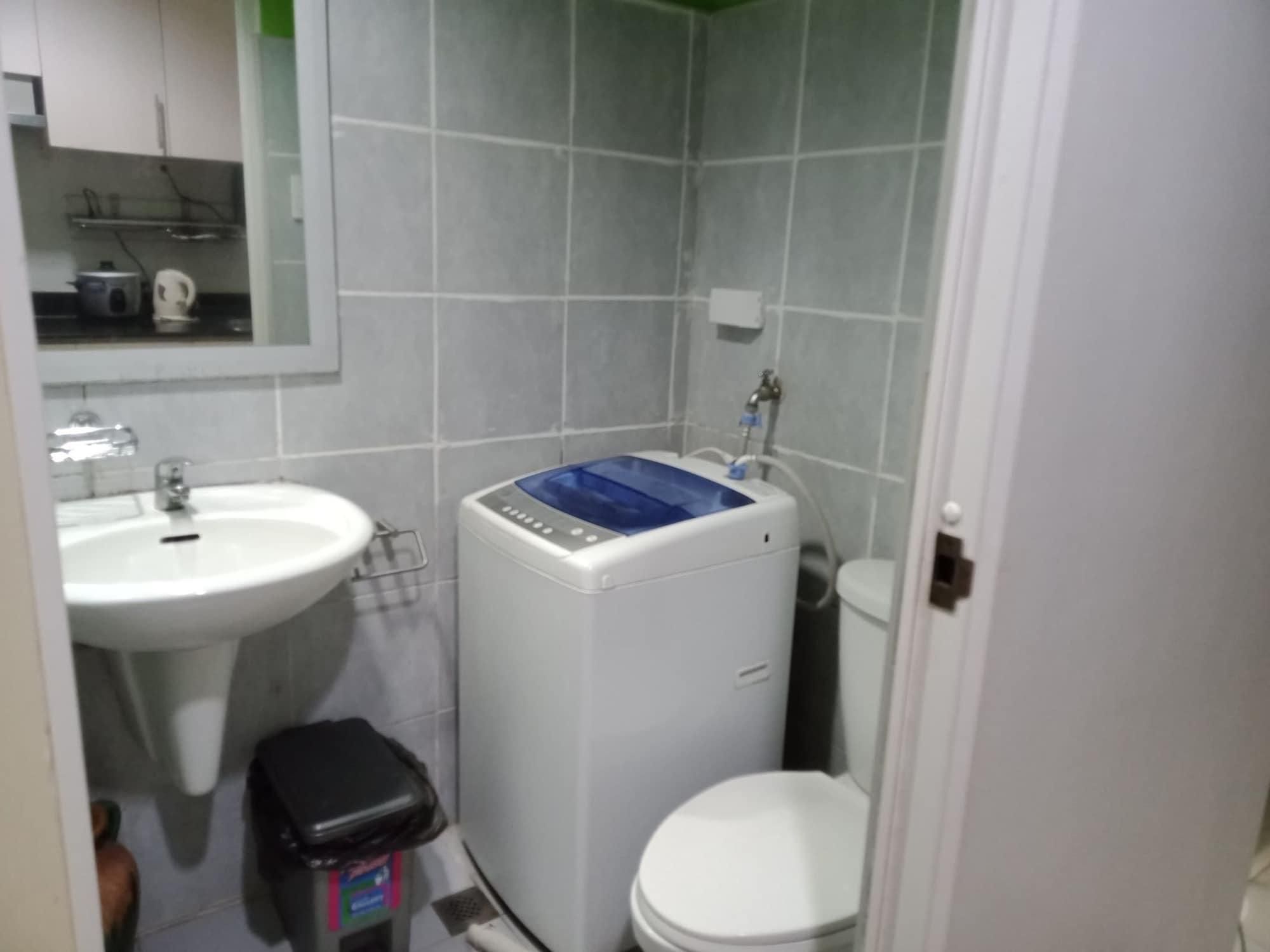 Un baño pequeño con lavamanos, inodoro y lavadora.