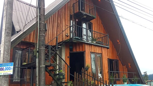 A wooden house with a balcony and a staircase leading to the entrance. - The heaven wood cabin (Nuwaraeliya)