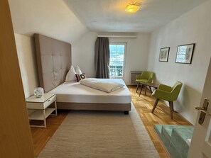 A hotel room with a bed, a desk, a chair, and a window with a view. - Large mountain house in Mitterberg near Hauser Kaibling (Mitterberg)