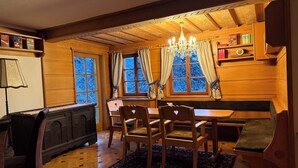 A cozy cabin interior with a wooden interior, a dining area with a bench, and a chandelier. - Large mountain house in Mitterberg near Hauser Kaibling (Mitterberg)