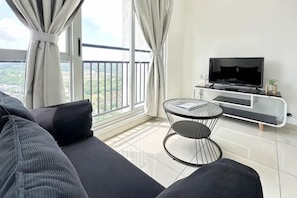 A modern living room with a sofa, a TV, a small table, and a balcony view. - ABHome [Friday Suite] Midas Seri Alam #Masai #JB (Plentong)