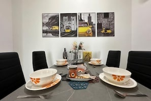 A dining table set with bowls, plates, and cutlery, surrounded by chairs. - ABHome [Friday Suite] Midas Seri Alam #Masai #JB (Plentong)