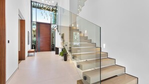Ein modernes Interieur mit einer Glasstiege, einer hölzernen Bank und einem Blumentopf.