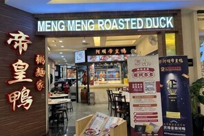 A restaurant named 'MENG MENG ROASTED DUCK' with a sign in English and Chinese, a counter with food items, and a menu stand with promotional materials. - ABHome [Family Suite] KSL D'Esplanade #Pool View #JB (Johor Bahru)