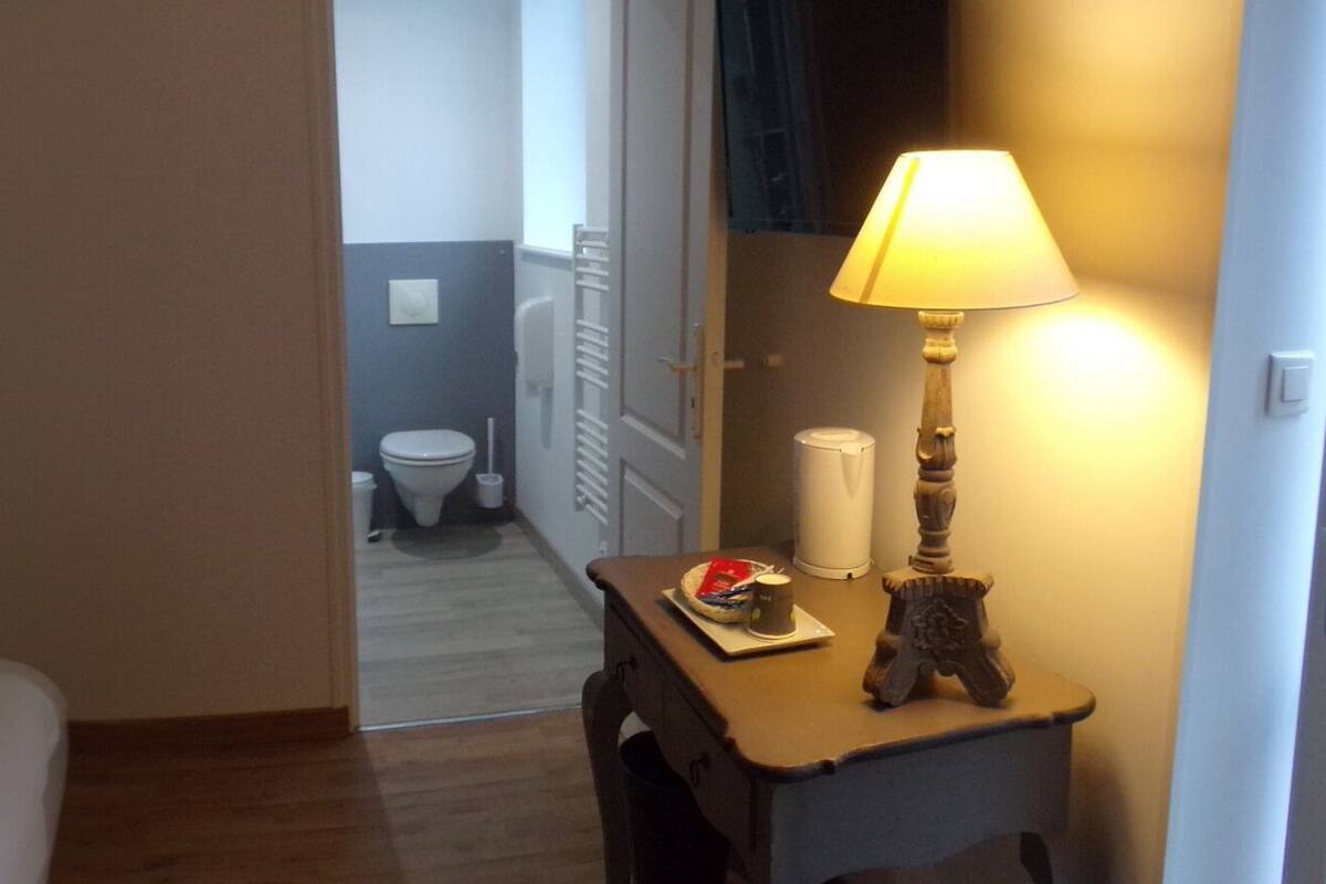 Ein Hotelzimmer mit Bett, Nachttischen, einer Lampe und einem Kleiderschrank.