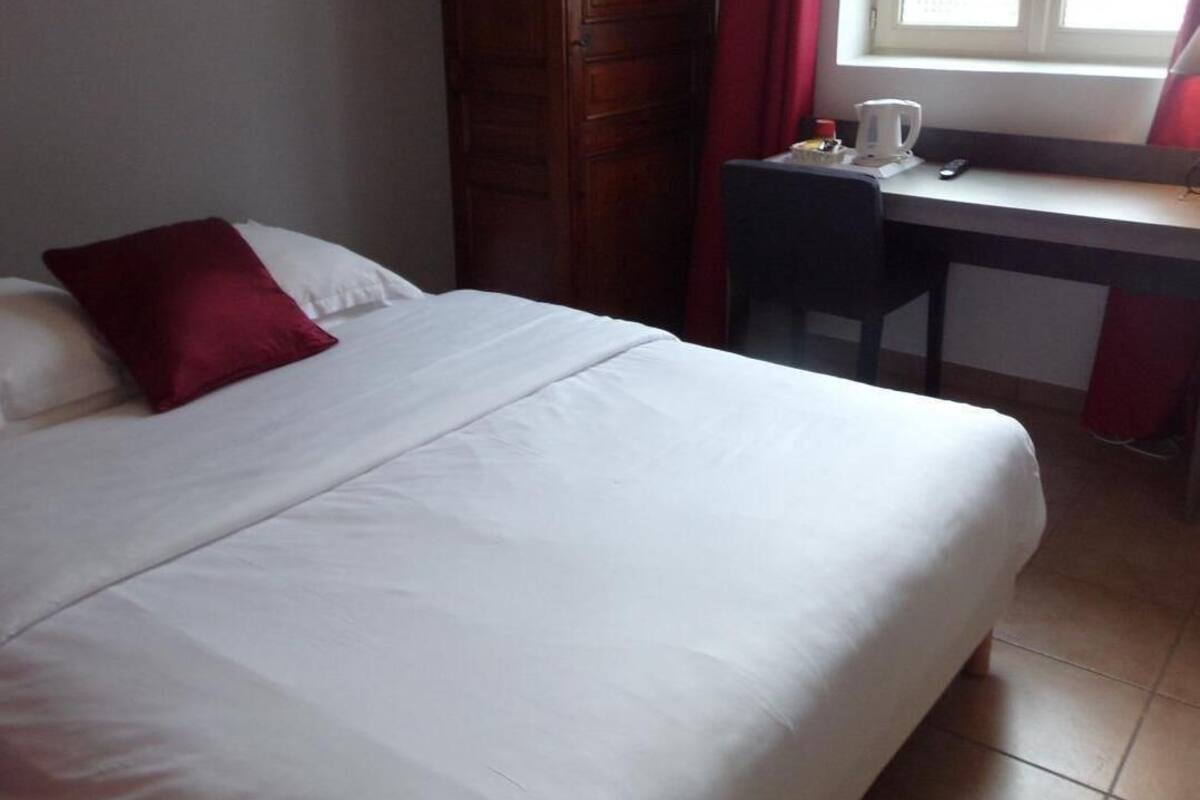 Ein Hotelzimmer mit einem Bett, einem Schreibtisch und einem Fenster.