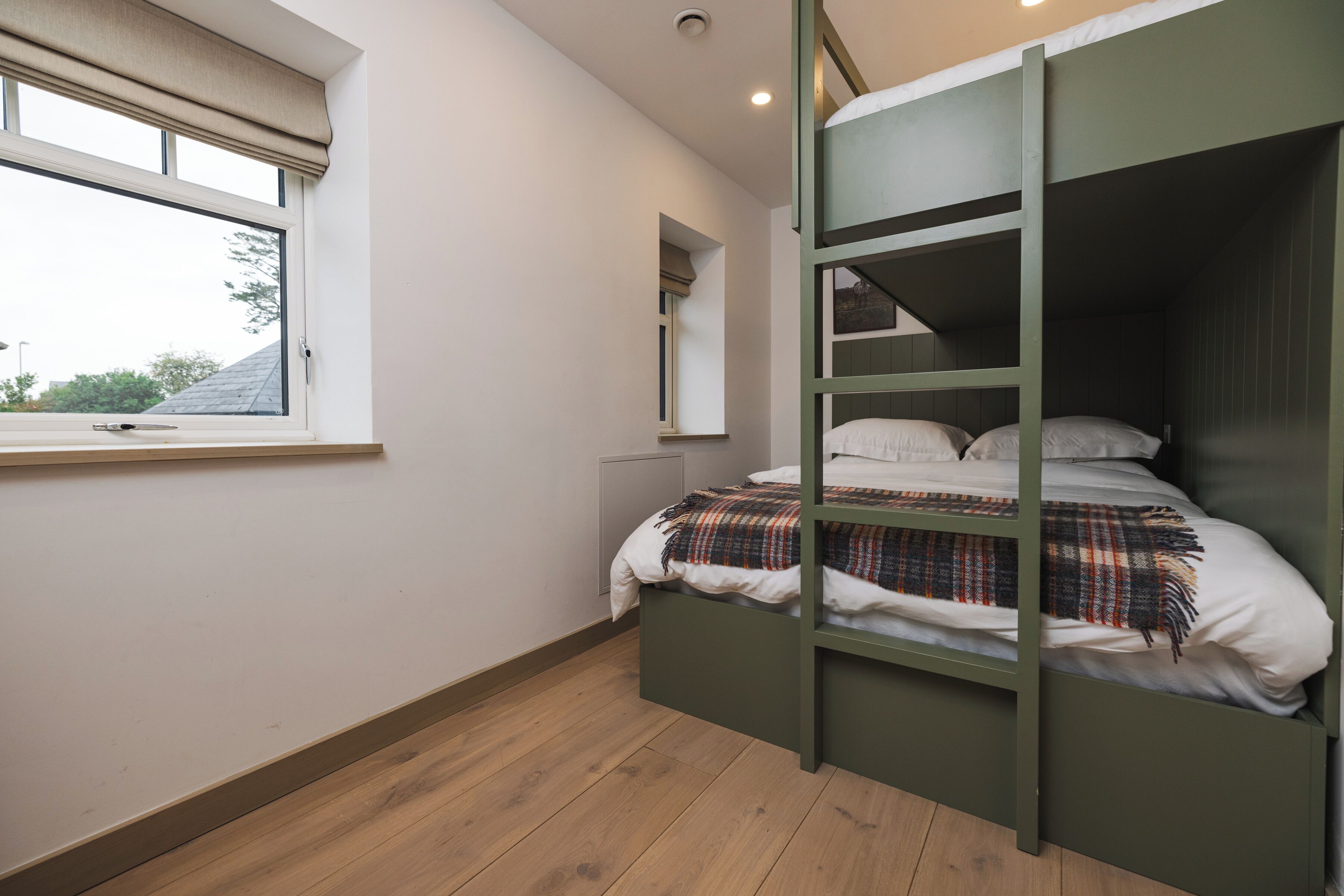 Una habitación con literas, una ventana y un radiador.