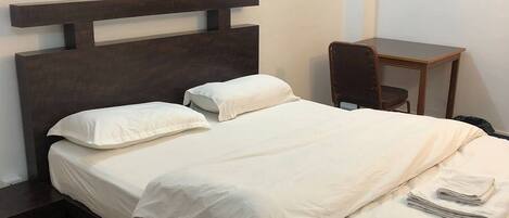 Tabla de planchar con plancha, internet y ropa de cama