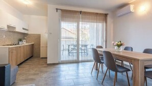 Eine moderne Küche mit Holzausstattung, einem eingebauten Ofen und einem Essbereich mit Holztisch und -stühlen.