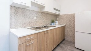 Eine moderne Küche mit weißen Schränken, einer gefliesten Rückwand und einem Einbauofen.
