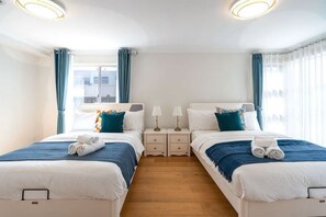 A double room with two beds, bedside tables, lamps, and a window with curtains. - Spacious 4B House in PointCook (Point Cook)