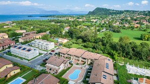 Zona residencial con casas, piscina y vista al mar.