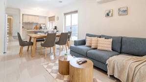 Un apartamento moderno con comedor, sofá y mesa de centro.