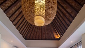 A modern living room with a wooden ceiling, a dining area with a wooden table, and a kitchen in the background. - Marijo Villa 2BR Private Pool Mins to Central Ubud (Ubud)