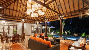 An outdoor patio with a dining area, a sofa, and a pool. - SPV Nusa Dua Luxury Traditional Design Nusa Dua (Nusa Dua)