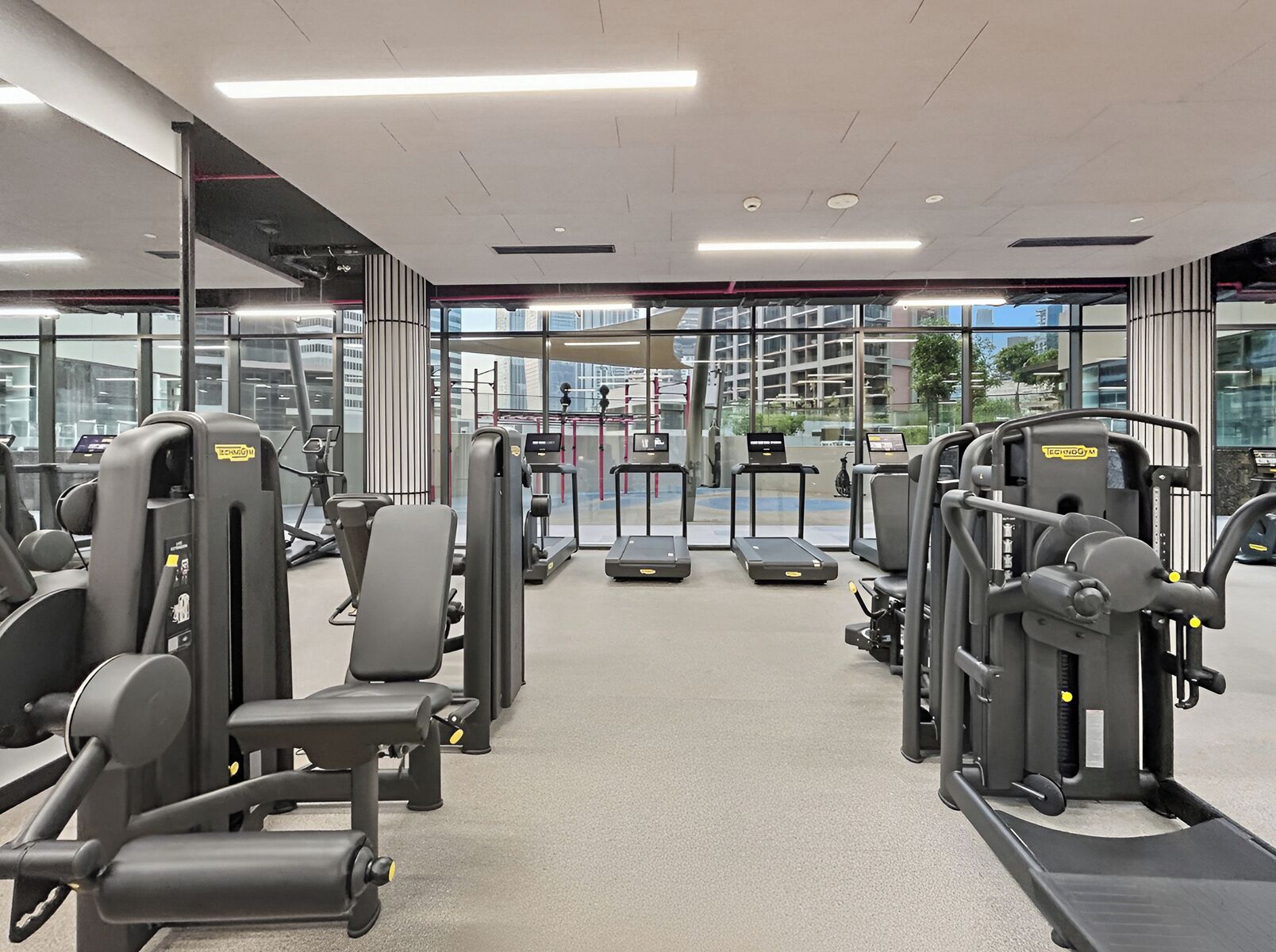 A modern gym with various exercise machines, treadmills, and weight stations.