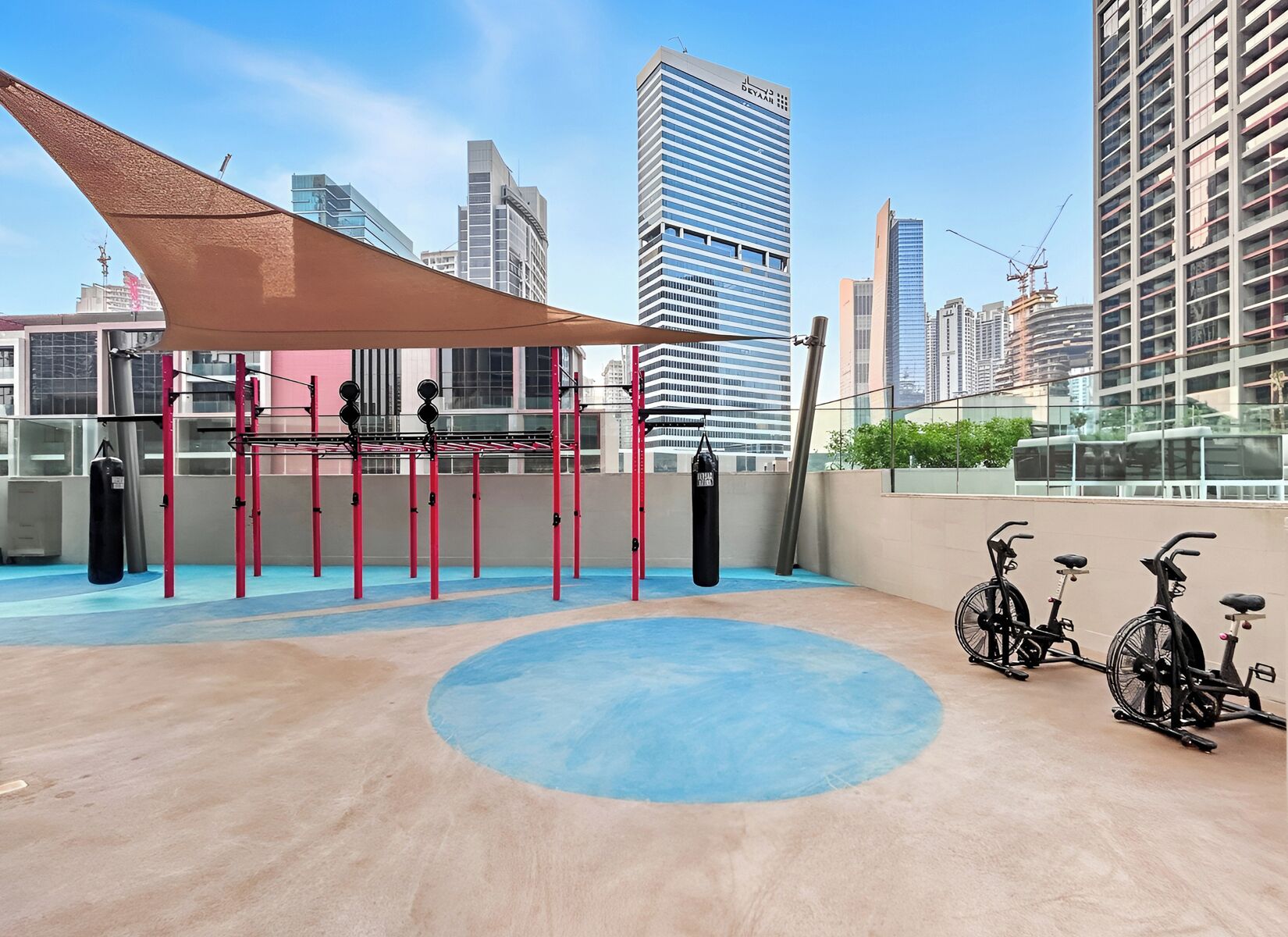 Une salle de sport située sur le toit, équipée de matériel d’exercice, d’un tapis bleu et de vélos.