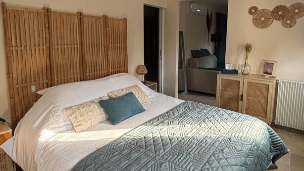 A bedroom with a bed, bedside tables, a wardrobe, and a door leading to another room. - Grenache room (La Garde-Adhémar)