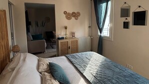 A bedroom with a bed, a dresser, a radiator, and a window with curtains. - Grenache room (La Garde-Adhémar)
