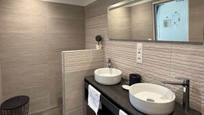 A modern bathroom with two large sinks, a mirror, and a small trash bin. - Grenache room (La Garde-Adhémar)