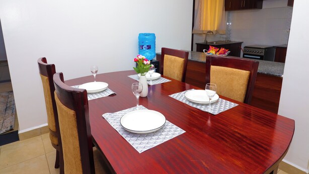 A dining table set with plates, glasses, and a vase of flowers.