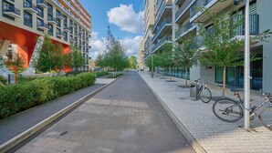 Una calle urbana moderna con una acera pavimentada, árboles y bicicletas estacionadas.