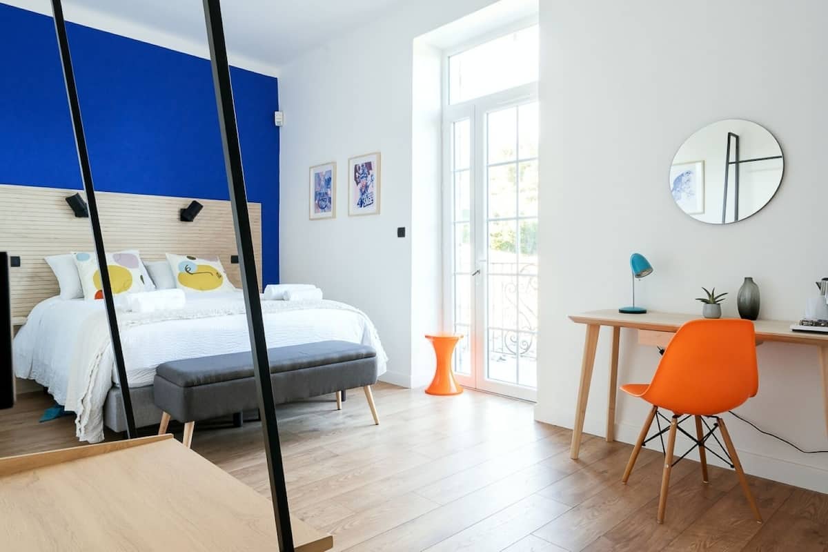 Een moderne slaapkamer met een bed, een bureau en een stoel.