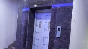 An elevator with a marble wall and a blue light strip. - Hotel Radhe Krishna (Khatoo)