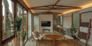 A modern interior with a large window, a wooden ceiling, a TV, and a seating area. - Pebble Lanta - Seaview Stay (Ko Lanta)