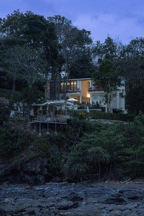 A modern house with a balcony, surrounded by dense vegetation. - Pebble Lanta - Seaview Stay (Ko Lanta)