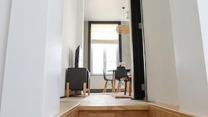 En modern inredning med en trätrappa som leder upp till en matplats med ett bord och stolar.