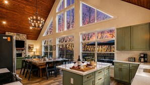 Una cocina amplia con techos altos, ventanas grandes y una chimenea de piedra.