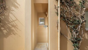 Um corredor estreito com uma porta, uma pequena janela e uma placa indicando o quarto 460.